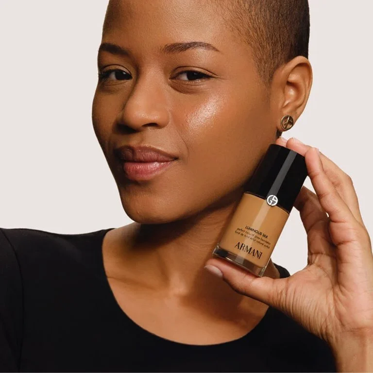 Makeup Woman holding a bottle of Giorgio Armani Beauty Luminous Silk Foundation